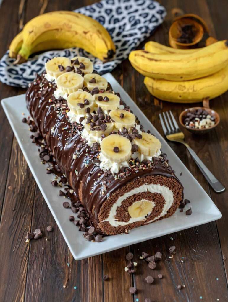 Bûche roulée chocolat banane avec glaçage brillant et décor de rondelles de banane