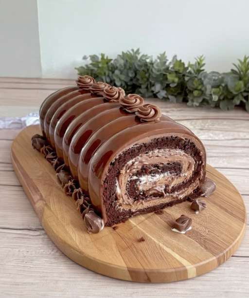 Bûche Kinder Bueno nappée de chocolat au lait, décorée de morceaux de Kinder Bueno et traits de chocolat