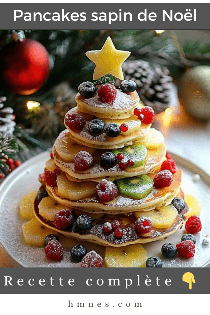 Pancakes sapin de Noël empilés avec fruits rouges et bananes, décorés de sucre glace et d’une étoile au sommet sur une assiette de fête.
