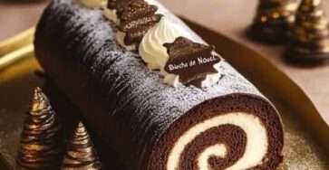 Bûche chocolat mascarpone roulée garnie de crème vanille et recouverte de ganache brillante.
