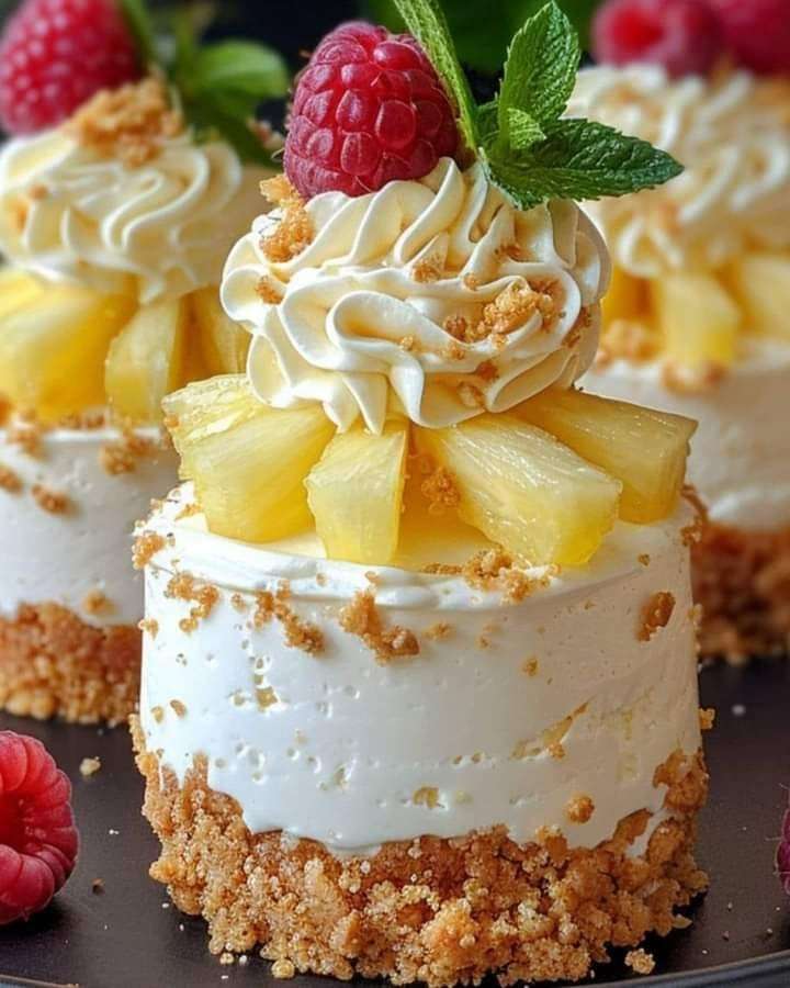 Cheesecake sans cuisson à l’ananas décoré de chantilly et framboises sur un plat de service.