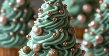 Cupcakes sapin de Noël décorés avec un glaçage vert en forme de sapin et des perles de sucre brillantes.