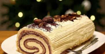 Bûche tiramisu Noël roulée, saupoudrée de cacao et décorée de grains de café