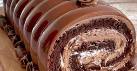 Bûche Kinder Bueno nappée de chocolat au lait, décorée de morceaux de Kinder Bueno et traits de chocolat