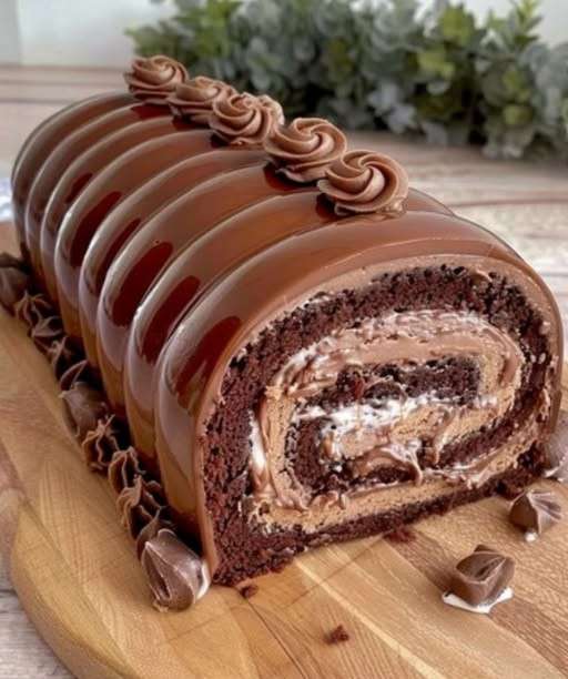 Bûche Kinder Bueno nappée de chocolat au lait, décorée de morceaux de Kinder Bueno et traits de chocolat