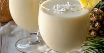 Punch coco Noël servi dans des verres décorés de noix de coco râpée et tranches d’ananas