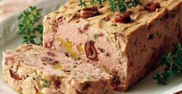 Terrine volaille châtaignes aux herbes, avec morceaux visibles et décoration de châtaignes entières