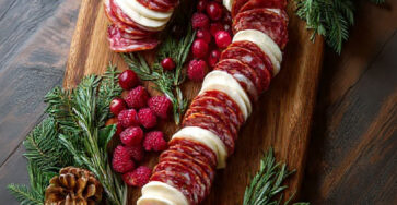 Canne de Noël apéritive composée de charcuterie, fromage, fruits rouges et romarin