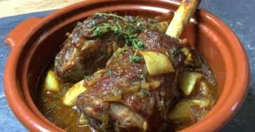 Souris d’agneau confite au four avec sauce réduite, oignons fondants et jus brillant