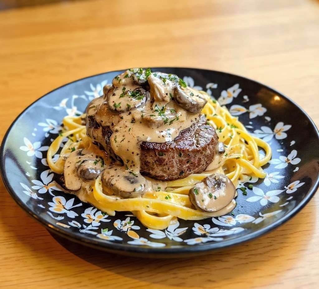 Filet mignon de porc nappé de sauce crémeuse aux champignons servi avec tagliatelles