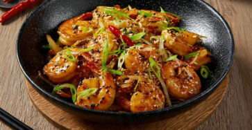 Wok de crevettes caramélisées soja sésame avec oignons verts et graines de sésame