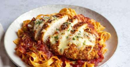 Escalope de poulet parmigiana gratinée servie avec tagliatelles et sauce tomate