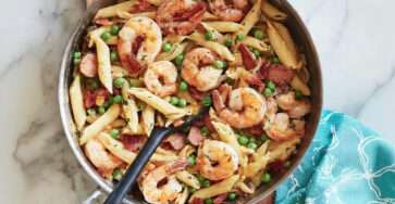 Penne crémeuses crevettes saucisse et petits pois servies chaudes dans une assiette