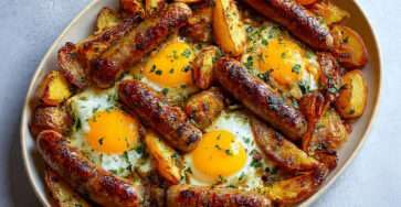 Saucisses au four avec pommes de terre rôties et œufs au plat