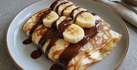 Crêpes banane chocolat pliées en triangle avec rondelles de banane, sauce chocolat fondante et sucre glace