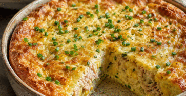Quiche sans pâte thon, maïs et ciboulette dorée au four dans un plat rustique avec salade verte et texture moelleuse.