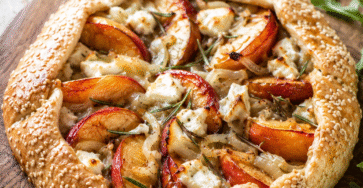 Tarte rustique nectarines salée au chèvre frais et romarin dorée au four sur une table rustique avec salade fraîche.
