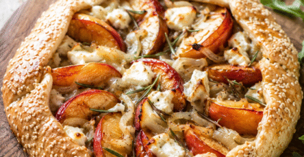 Tarte rustique nectarines salée au chèvre frais et romarin dorée au four sur une table rustique avec salade fraîche.