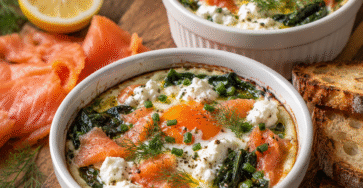 Œufs cocotte aux épinards, saumon fumé et ricotta cuits au four dans des ramequins.