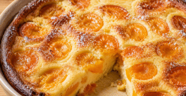 clafoutis aux abricots moelleux avec une part découpée et des fruits fondants