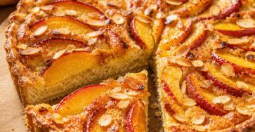 Tarte pêches aux amandes avec une part fondante découpée
