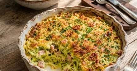 Gratin courgettes jambon et parmesan doré au four dans un plat rustique avec courgettes râpées fondantes et salade verte.